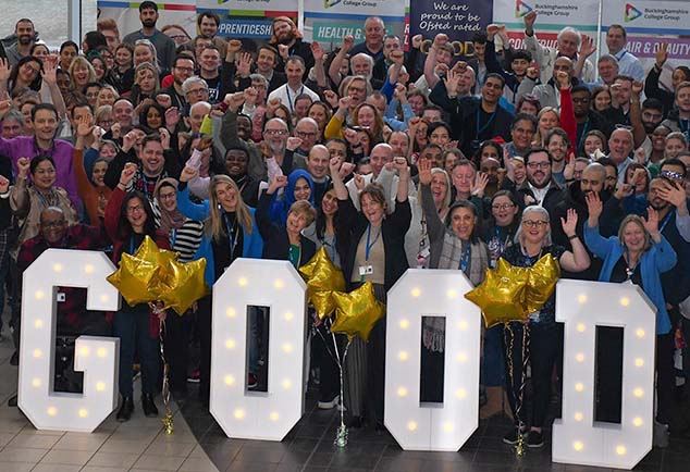 College staff standing together in front of large letters reading 'Good'