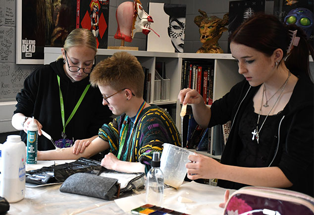 Student working in studio creating special effects on arms