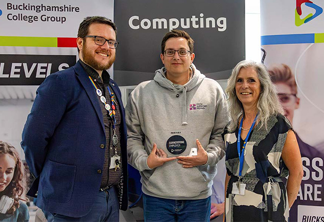 Staff from Buckinghamshire College Group standing with an employer holding glass plaque