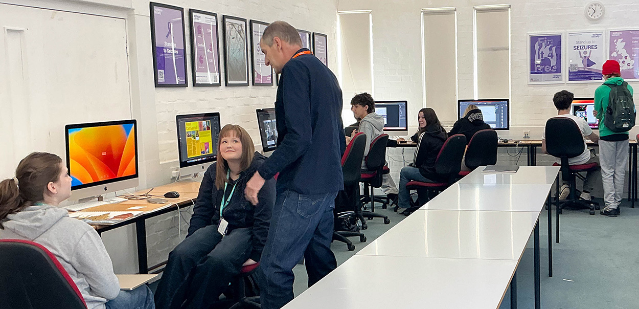 Tim speaks with Graphic Design students at their computers