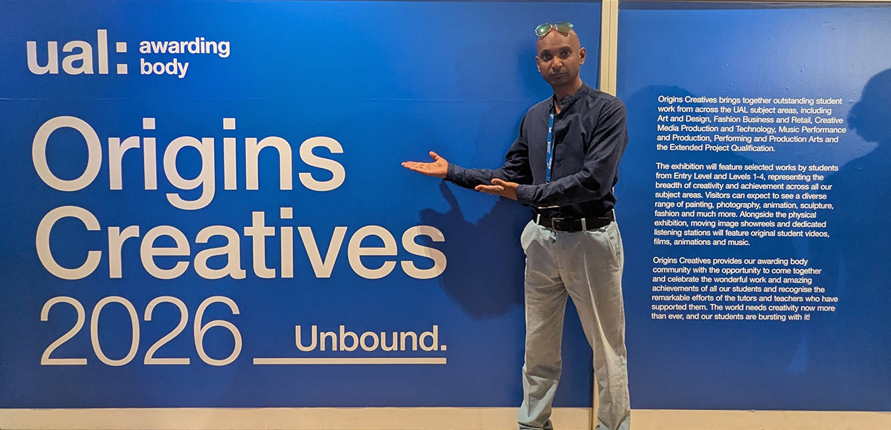 Graphic Design Tutor standing in front of Origins Creatives Sign